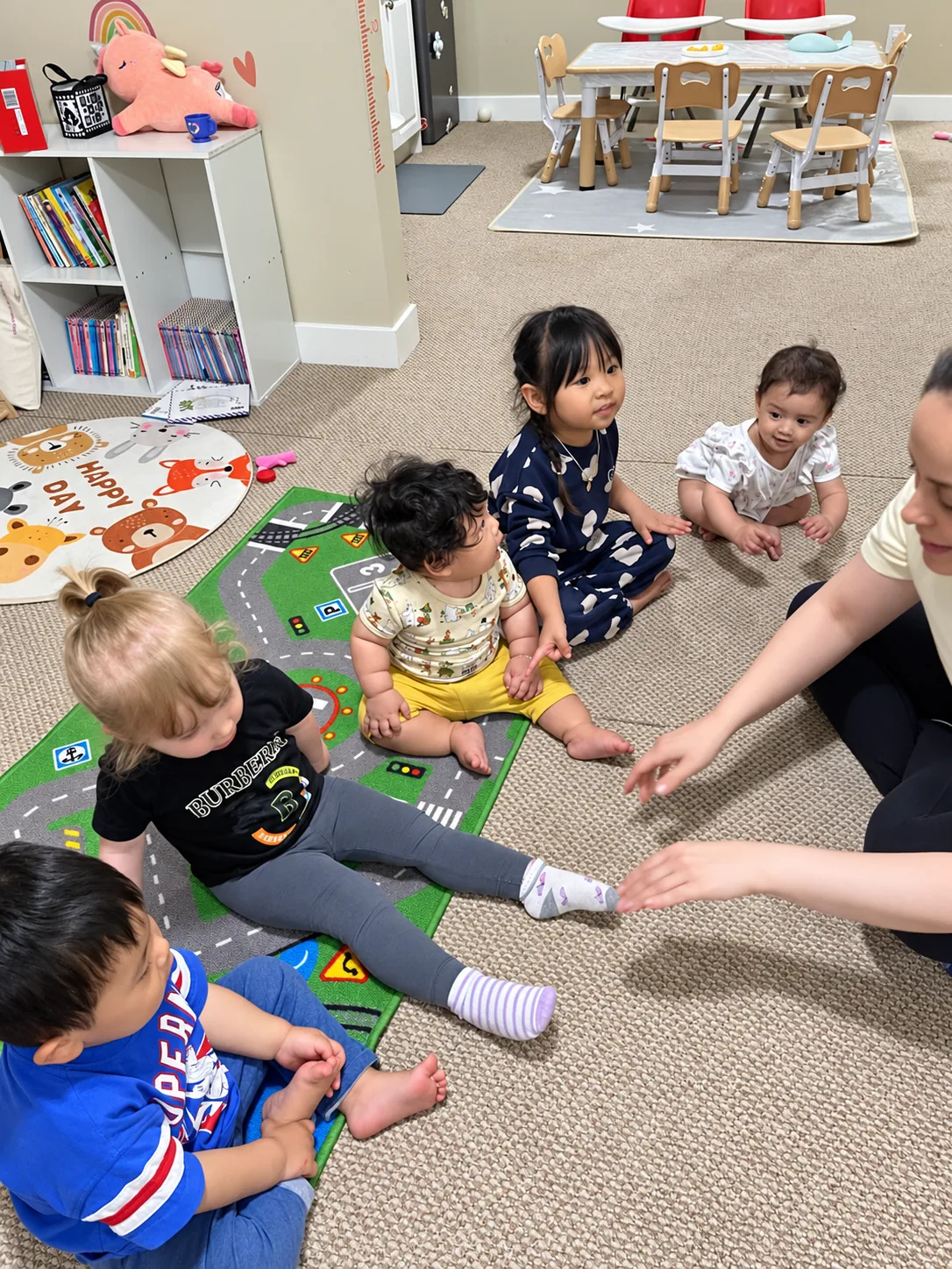 Children and their educator enjoying circle time in the playroom