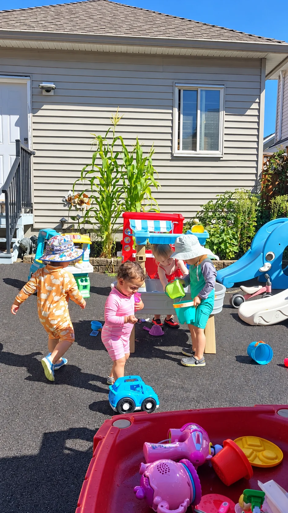Four children enjoying outdoor play around the water tables